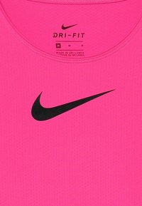Camiseta deportiva Nike Dri-FIT en color rosa con el logo de swoosh negro. Fabricada con tejido texturizado y transpirable, presenta un escote redondeado y etiqueta en su interior.