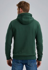 Green hooded sweatshirt with a soft texture, ribbed cuffs and hem, and a relaxed fit. Back view shows seam detailing and no visible logos.