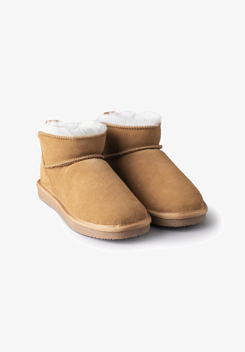 Brown suede ankle boots with a shearling lining, rounded toe, and flat rubber sole. Features a stitched seam and cuffed design.