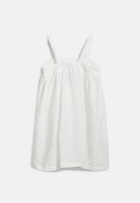 Vit bomullsklänning med justerbara remmar, broderad blommönster och rynkad midja. Lättviktsmaterial med en mjuk textur.