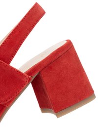 Red suede block heel sandal with adjustable strap and beige inner sole, photographed on white background.