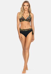 Zestaw bikini składający się z kolorowego topu na halter w zielono-czarnym wzorze, z pasującymi czarnymi majtkami i wiązaniem w talii.