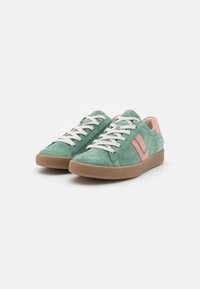 Grønne semskede sneakers med lyserøde aksenter, som har hvide snørebånd, en afrundet tå og en struktureret brun gummisål.