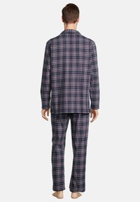 La set di pigiama in flanella a quadri blu marino presenta una camicia con bottoni e colletto, accompagnata da pantaloni coordinati, entrambi realizzati in un morbido tessuto testurizzato.
