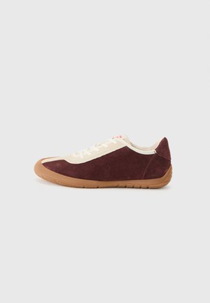 Baskets en daim bordeaux avec des accents beiges, à lacets à l'avant, semelle en caoutchouc et bout arrondi. Présente un design minimaliste et une surface texturée.