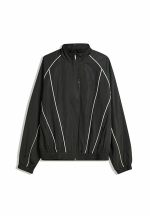 Crna windbreaker jakna s visokim ovratnikom, elastičnim manžetama i bijelim dijagonalnim prugama. Ima prednji džep sa patentnim zatvaračem i uklopljeni rub.