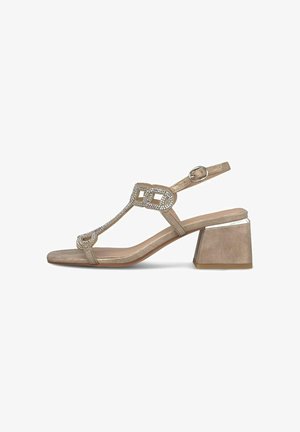 Sandalia de tacón beige con correa en el tobillo, tira en T adornada con pedrería, punta cuadrada abierta y tacón ancho con detalle metálico.