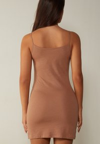 Vestido mini ajustado color malva con tirantes finos, confeccionado en una tela suave y elástica. Diseño sencillo sin patrones, bordes sin costuras y una textura suave.