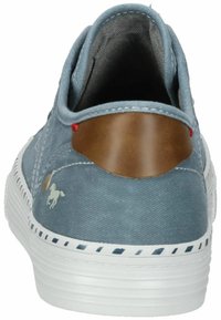Baskets en tissu bleu avec un accent en cuir marron au talon, semelle blanche et couture décorative. Présente un petit logo de cheval sur le côté.