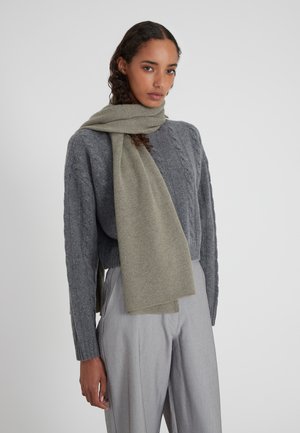 Hellgrauer Wollschal, der über einen dunkelgrauen Grobstrickpullover gelegt ist. Glatte Textur, mit sauberen Kanten und ohne sichtbare Muster. Lässige Passform.
