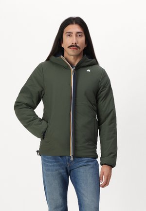 Groene gevoerde jas met capuchon, voorzien van een ritssluiting met gekleurde accenten, twee zijzakken en een klein logo op de borst.