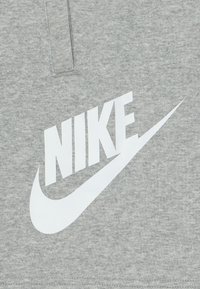 Sivý bavlnený sweatshirt s veľkým bielym logom Nike a dizajnom swoosh, hladká textúra a klasický okrúhly výstrih.