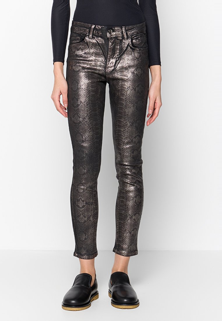 Metallic Schlangenprint-Leggings in Dunkelgrau mit schmaler Passform, mittelhohem Bund und Fünf-Taschen-Design. Kombiniert mit schwarzen Slippern.