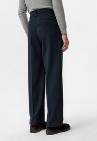 Donkerblauwe op maat gemaakte broek met een rechte pijp, voorzien van een achterzak, knoopsluiting en een gladde wolachtige textuur.