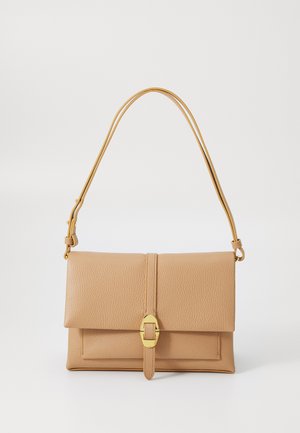 Bolsa de mão em pele bege com um design estruturado, aba dobrável, ferragens douradas e uma alça de ombro ajustável.