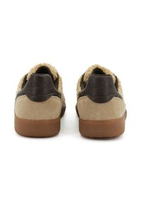 Scarpe in suede beige con dettagli in pelle marrone e una consistenza morbida al collare. Suole in gomma offrono aderenza e stabilità.