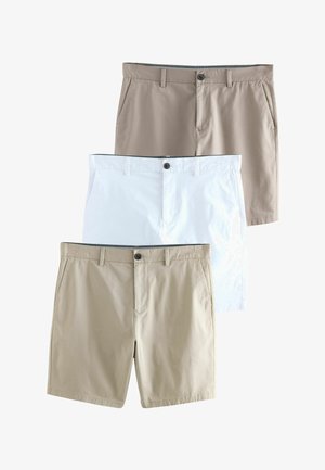 Tres pares de pantalones cortos chinos para hombre apilados, en colores marrón, blanco y beige, cada uno con presillas para cinturón, bolsillos frontales y cierres de botón.
