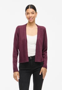 Burgundy open-front cardigan made of soft knit material, featuring long sleeves and ribbed cuffs, paired with a white top and black jeans.