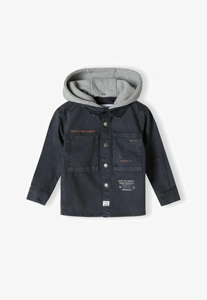 Dunkelblaue Jeansjacke mit grauem Kapuzenrand, ausgestattet mit Knopfverschluss, zwei Fronttaschen und bedruckten Textdetails auf der Brust und an der unteren Seite.