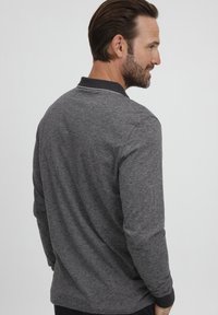 Hallide hall sleeves polo särk hall värviga, tekstureeritud kangaga, kontrastsete krae ja peente ääristustega, nähtav tagant.