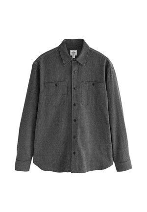 Camicia a maniche lunghe a righe bianche e nere con chiusura con bottoni, due tasche sul petto e colletto classico; il tessuto ha un motivo a rilievo.