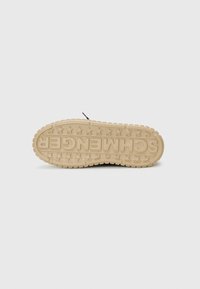La semelle extérieure des chaussures présente un matériau en caoutchouc beige texturé avec un design en motif étoilé et une marque en relief indiquant "SCHMENGER."