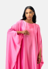 Lång, flödande rosa satin-klänning med vida ärmar och rund halsringning. Har löst drapering och en slät, glänsande yta.