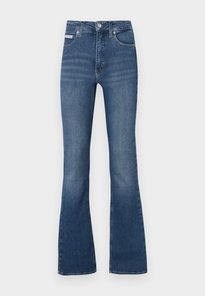 Kék farmer, harangszárú nadrág, magas derékkal, öt zsebes kialakítással és finom kopásokkal az elején. Gombos és zipzáras záródással rendelkezik.