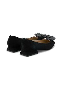 Ballerines en daim noir avec des talons carrés, ornées de décorations florales en relief noires dans la zone des orteils. Doublure intérieure lisse.