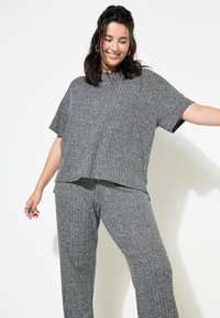 Ensemble de lounge en tricot côtelé gris comprenant un haut à manches courtes ample et un pantalon assorti avec une taille élastique, présenté sur fond blanc.