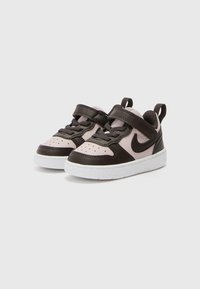 Baskets Nike pour tout-petits en cuir synthétique rose et marron foncé, avec une semelle en caoutchouc blanche, un design à lacets et une sangle ajustable.