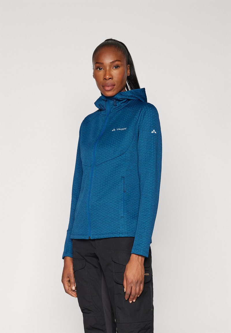 Casaco azul com fecho éclair, padrão texturizado, capuz e bolsos laterais. Apresenta um fecho frontal e detalhes do logótipo no peito e na manga.