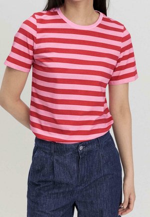 T-shirt à manches courtes rayé rouge et rose en coton, avec un col rond. Associé à un pantalon en denim foncé.
