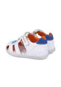 Sandali bianchi per bambini con lati aperti, interno arancione, dettagli blu sul tallone, cinturino in velcro e design giocoso sulla parte superiore. Suola in gomma.