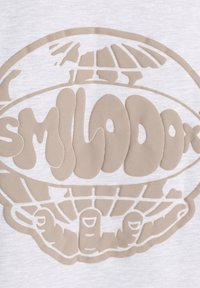 Camiseta de algodón gris claro con un gran gráfico en relieve en color beige de un globo sostenido por manos, acompañado del texto estilizado "SMLODOK".