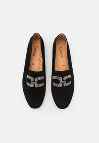 Schwarze Wildleder-Loafer mit einem dekorativen silbernen Kettenakzent an der Vorderseite. Glatte Textur, leicht abgerundete Zehenform und durchlöcherte Innensohle.