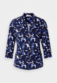 Camisa de botón azul marino con un patrón geométrico en azul y blanco, con mangas largas y un cuello clásico, hecha de tela suave.