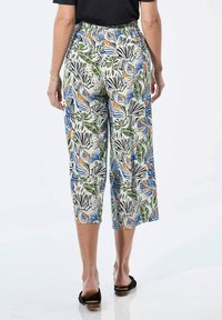 Bloemenprint cropped broek met een elastische tailleband. Heeft groene, blauwe, oranje en zwarte patronen op een lichte achtergrond.