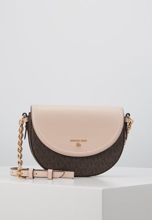 Petit sac bandoulière bicolore avec rabat beige et corps sombre à motif, chaîne dorée et bandoulière en cuir réglable sur surface blanche.