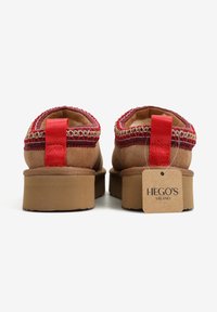 Brązowe zamszowe buty wsuwane z fakturowaną czerwoną i złotą plecioną lamówką, grubymi podeszwami i czerwonymi materiałowymi pętelkami do zakładania; metka z napisem "HEGO'S MILANO".