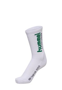Biała sportowa skarpetka o ryflowanej teksturze, z zielonym brandingiem "hummel" po boku i tekstem "MAY THESE SIDES" blisko palców.