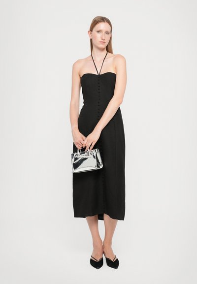 Black strapless dress with front buttons, knee-length. Paired with a small metallic silver handbag and black pointed flats. Simple design.