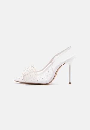 Pantof alb cu toc înalt, slip-on cu baretă la spate, cu vârf ascuțit, laterale transparente și decorat cu mici ținte perlate.