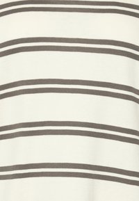 Randig stickad tyg med växlande ljusbeige och mörkbruna horisontella ränder, med en mjuk och slät textur.