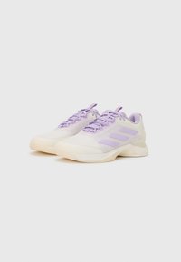 Scarpe sportive leggere in crema e lavanda, con una tomaia in rete, dettagli testurizzati e tre strisce viola sui lati.