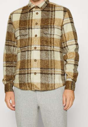 Braun und cremefarbig karierte Flanellhemden mit zwei Brusttaschen, abgerundetem Saum und braunen Knöpfen; weiche Textur und warmes Design, das sich gut zum Schichten eignet.