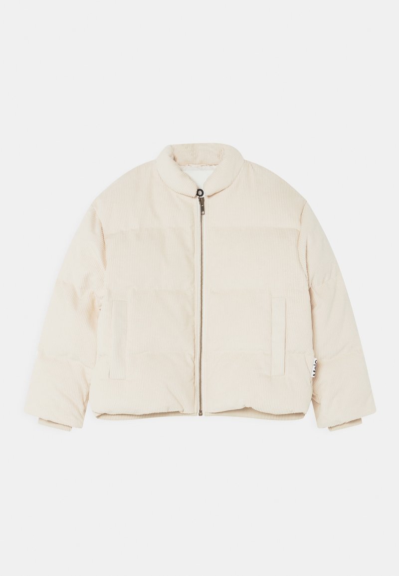 Veste matelassée beige en tissu côtelé, avec col rond, fermeture éclair frontale et deux poches latérales. Texture douce avec une coupe courte.