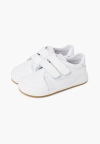 Scarpe bianche per bambini con doppie chiusure in Velcro, realizzate in materiale sintetico testurizzato, con suola in gomma e design della punta arrotondata.