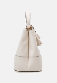 Ljus beige, texturerad läderväska med dragsko överdel, runt botten och guldfärgade detaljer. Har en liten tofs som extra detalj.