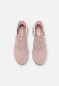 Sneakers slip-on em rosa claro com parte superior em malha respirável, detalhes texturizados e sola de borracha branca. Apresenta uma pequena aba no calcanhar.
